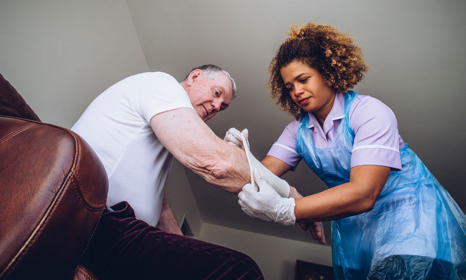 A nurse is helping an elderly man with his arm.